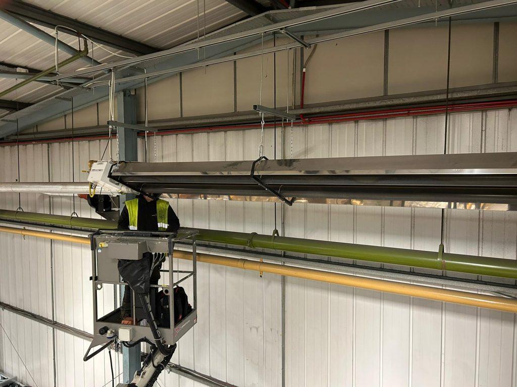 Photo shows engineer inspecting a radiant tube heating system.